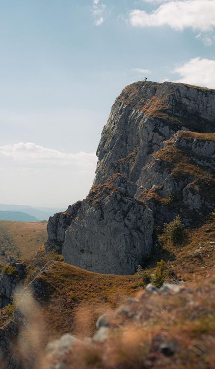 A rocky peak above autumn hills