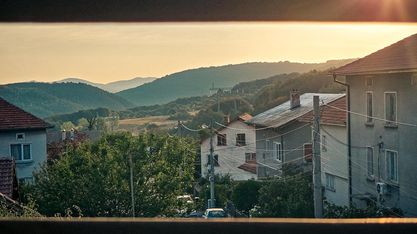 Hillside houses with mountains at sunset