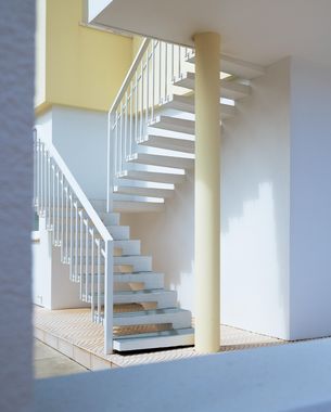 A white spiral staircase between two buildings