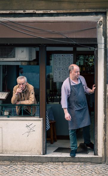 Two men at the doorway of a café